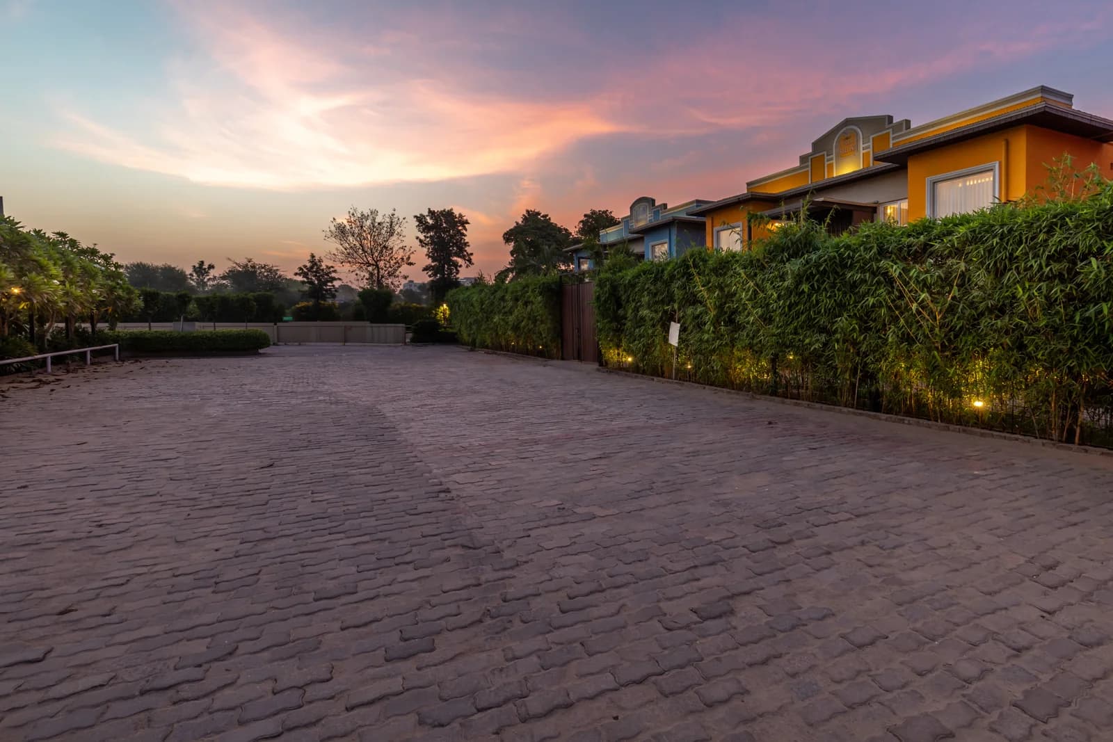 Cobblestone paved resort driveway and parking approach under colorful sunset sky