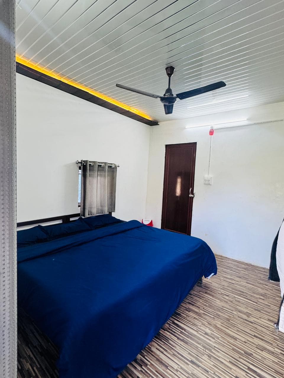 Solid cottage bedroom interior with king bed and cove lighting at Byasi Camps