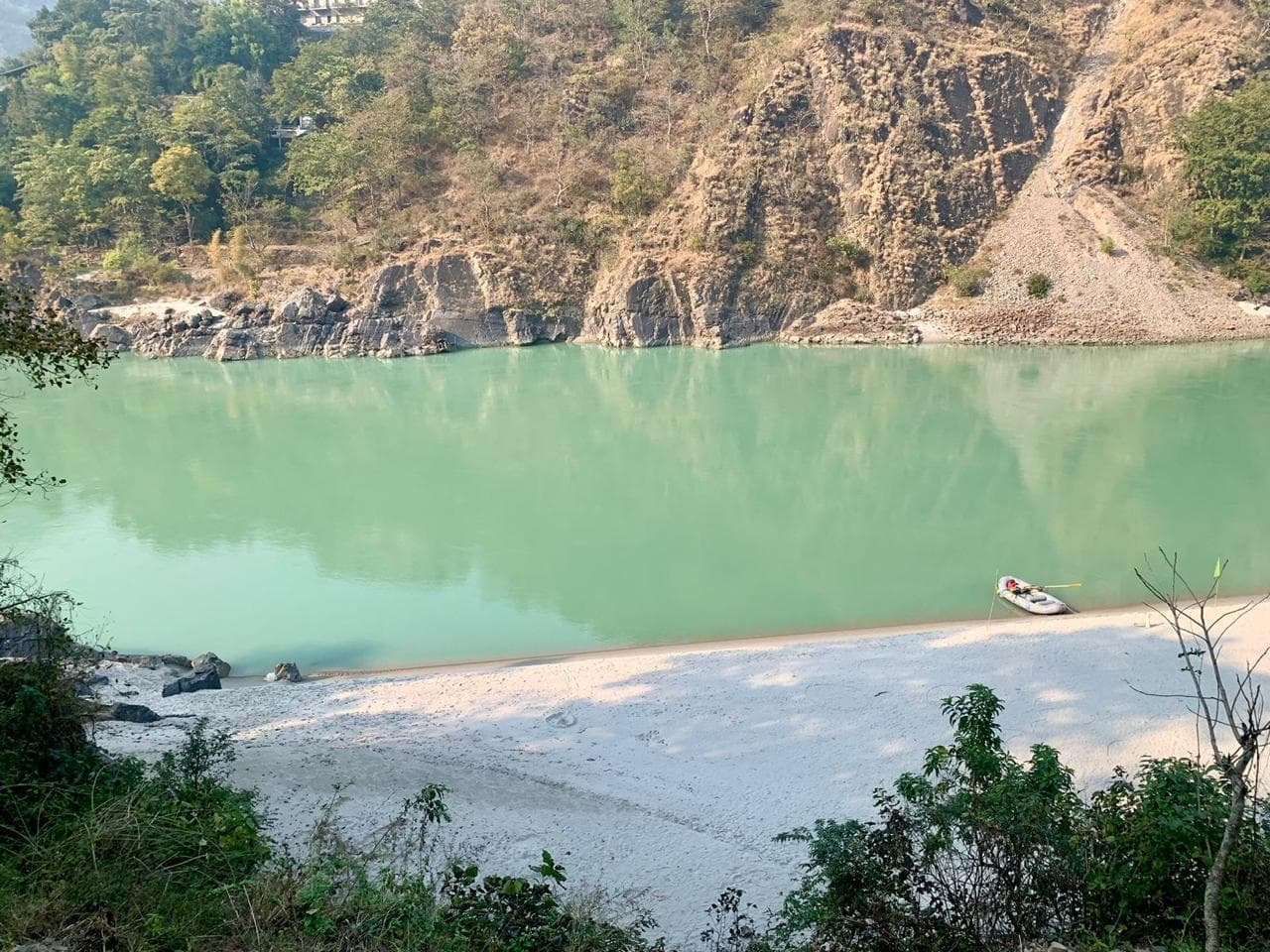 White sand river beach and rafting boat on the Ganga below Byasi Camps