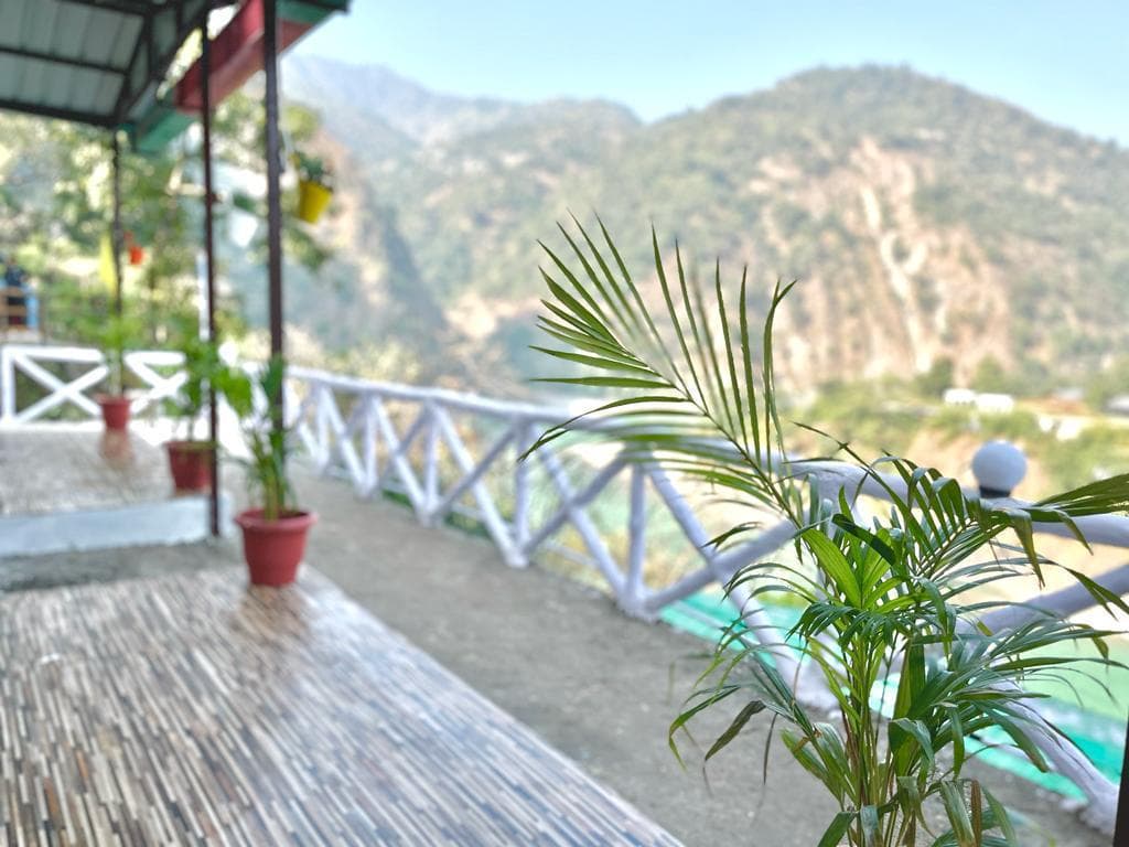 Mountain valley view from the cottage veranda railing at Byasi Camps
