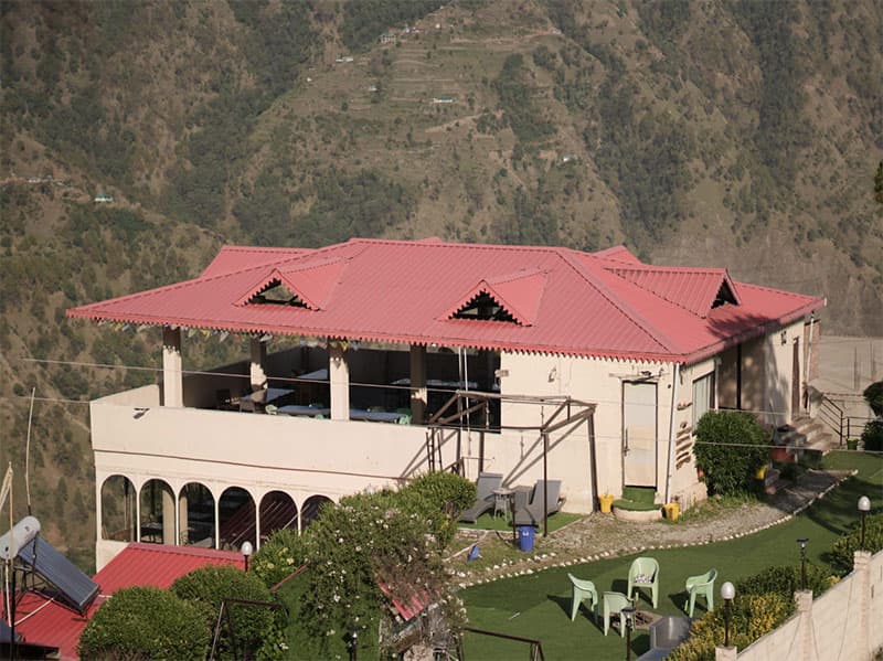 Stone pathway winding between mountain cottages at Chail Camps & Cottages