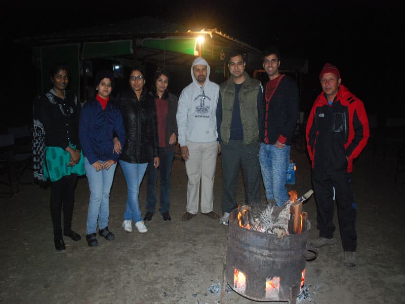 Evening bonfire brazier with guests gathered outdoors at Chakrata Camps & Cottages