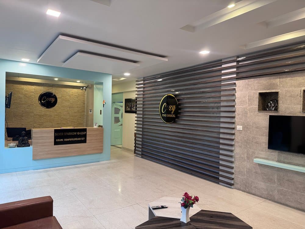 Clean glass-enclosed reception lobby counter at Cozypine Kanatal