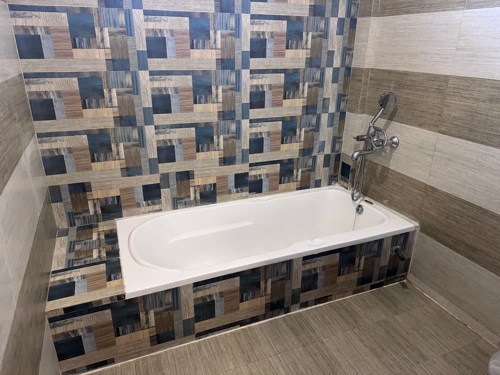 Modern en-suite bathroom with deep soaking bathtub at Cozypine Kanatal